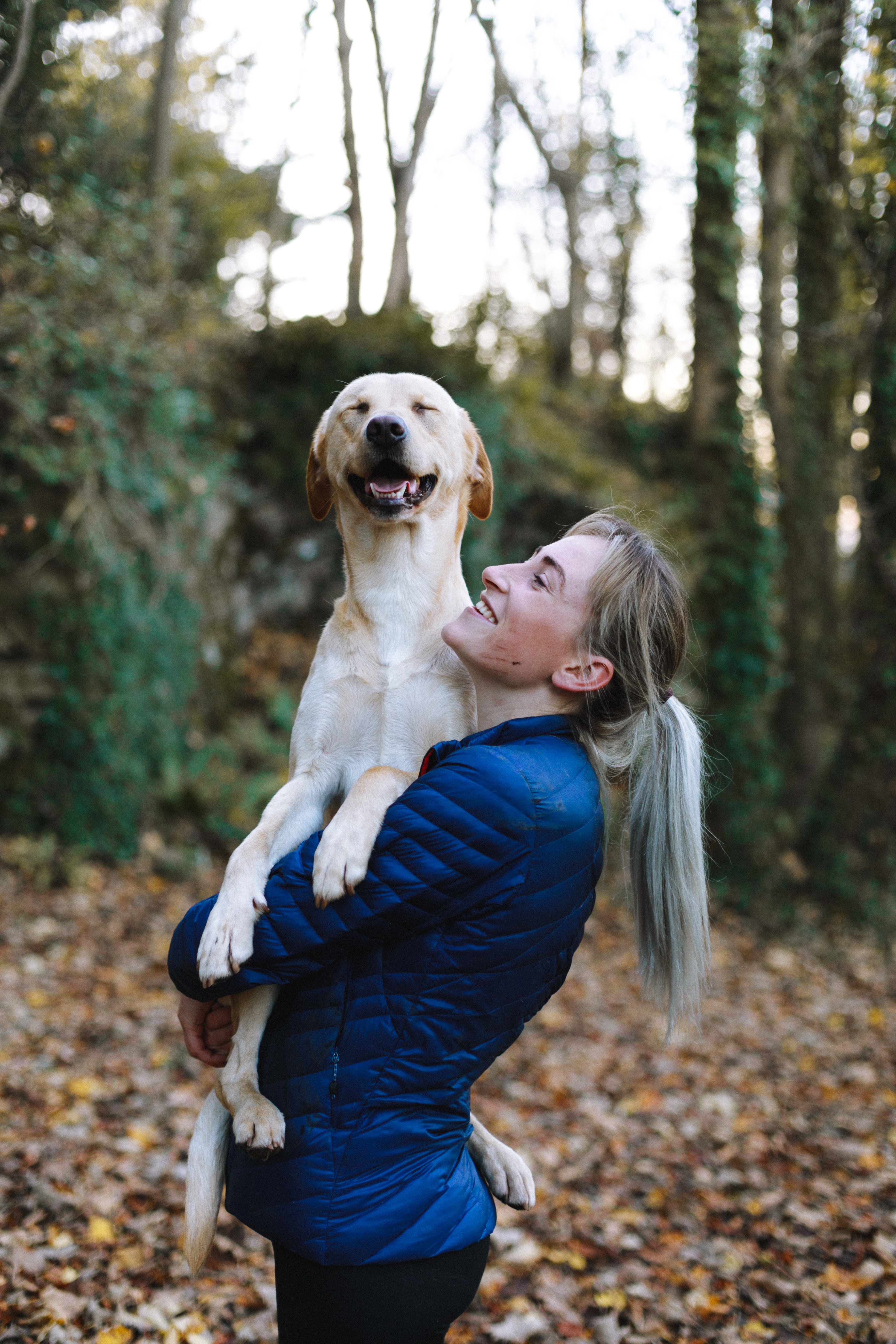 Dog owner holding her dog up after a walk in the park